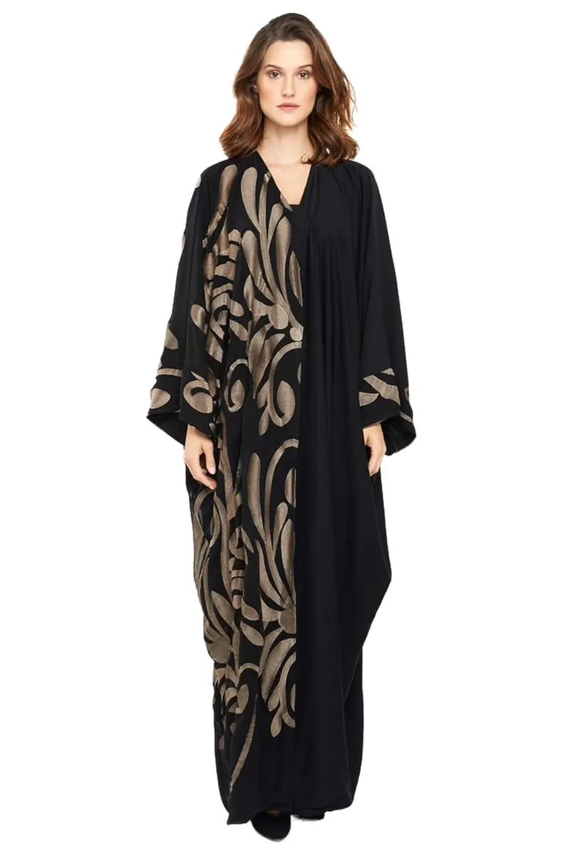 Model wearing a black and gold patterned abaya
